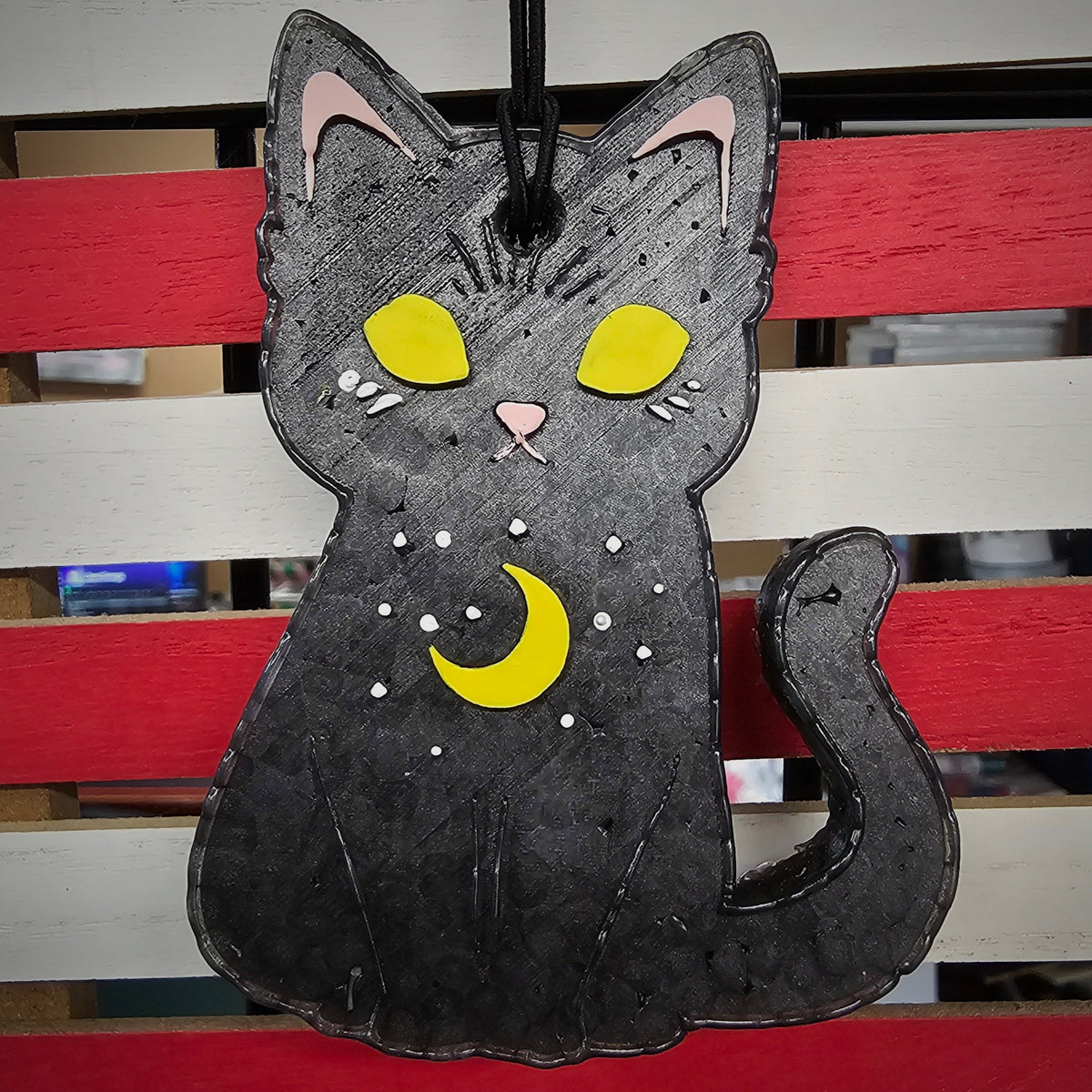 Black moon cat freshie with yellow eyes against striped background