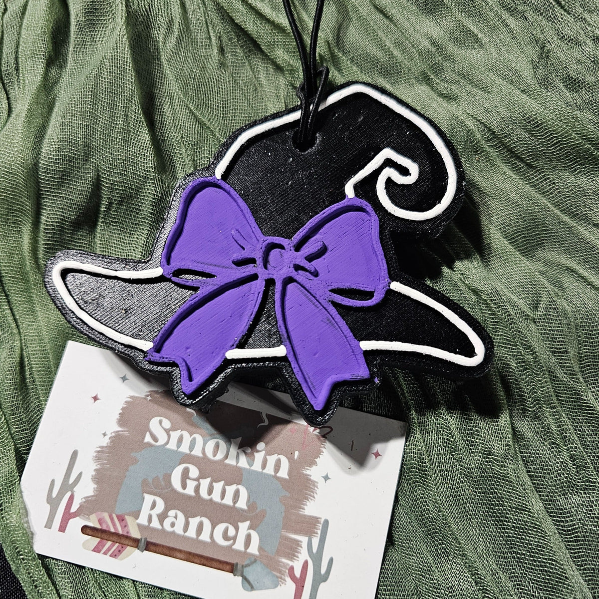 Black witch hat car freshie with a purple bow and white trim