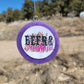 Purple round cardstock freshie with rodeo graphic hanging outdoors