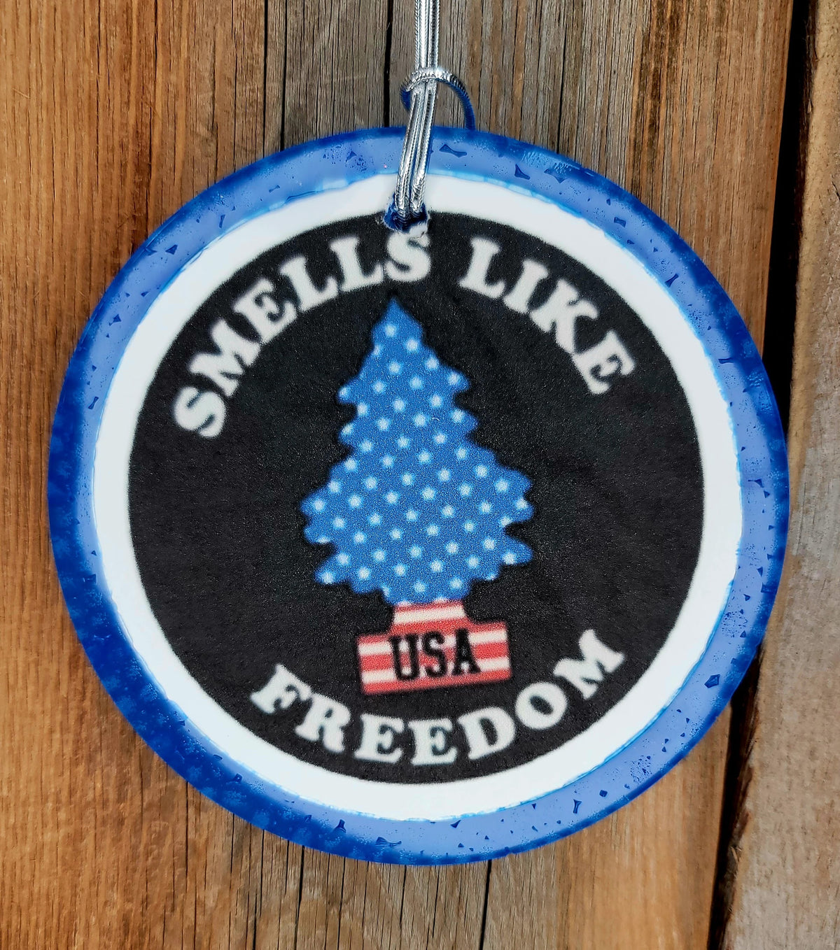 Blue round cardstock freshie reading Smells Like Freedom