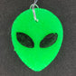 Neon green alien head freshie on dark background