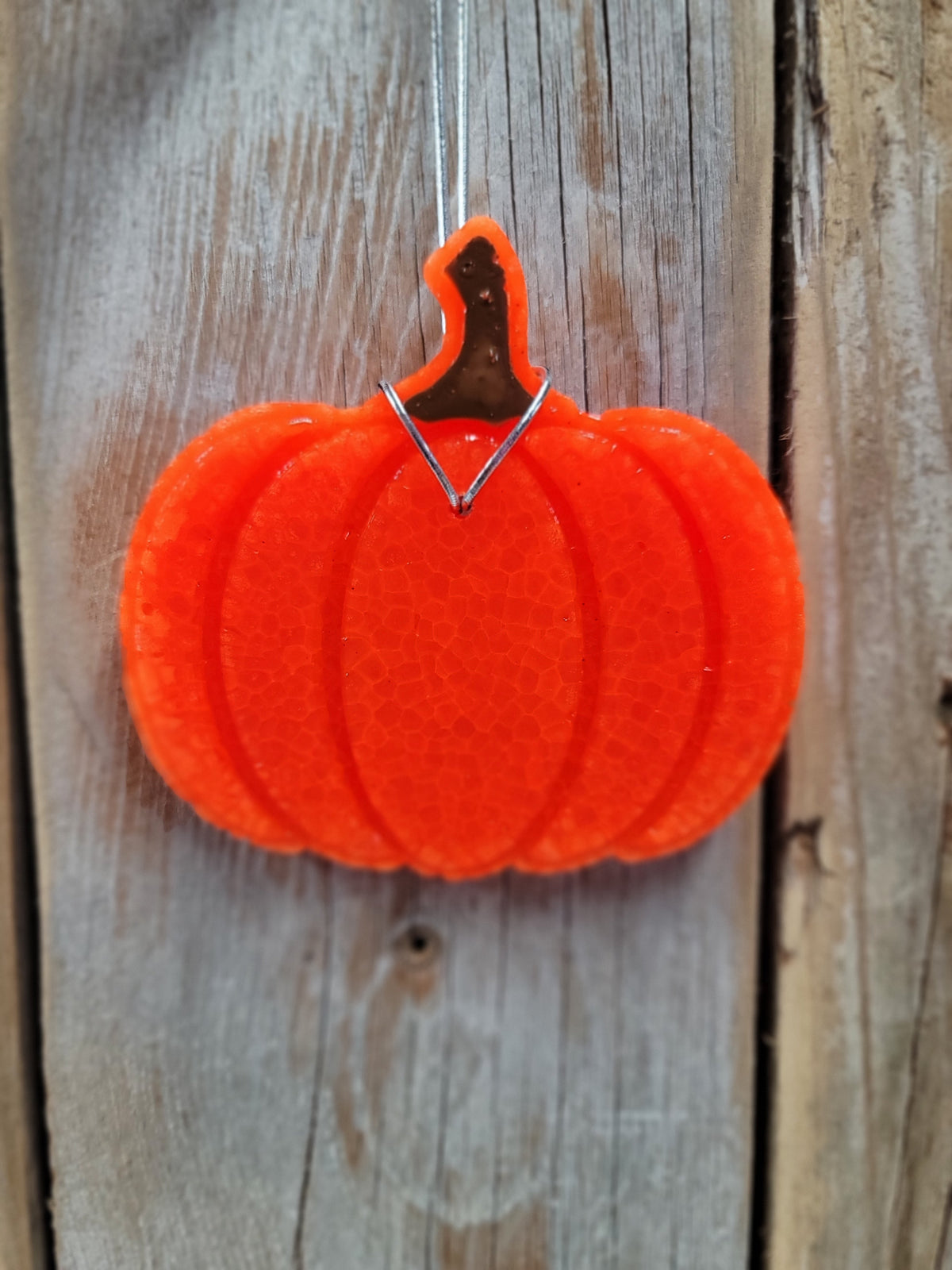 Orange pumpkin freshie hanging on wood