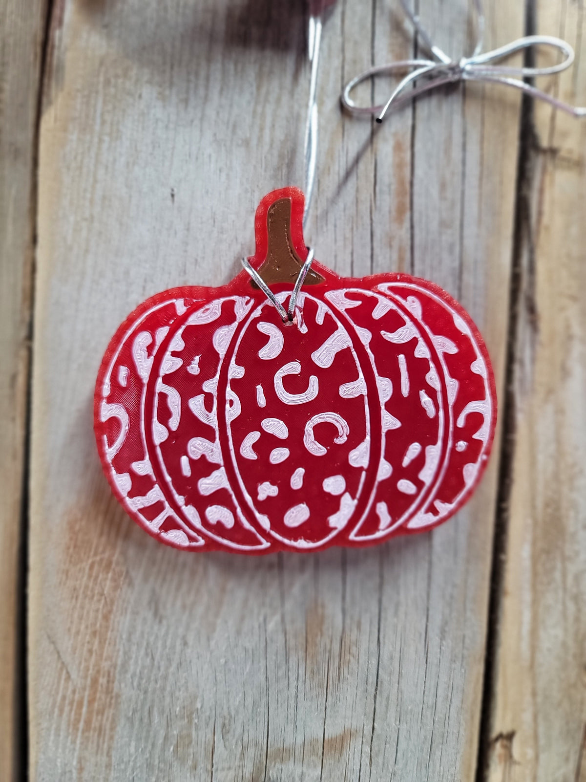 Red and white leopard print pumpkin freshie hanging on wood