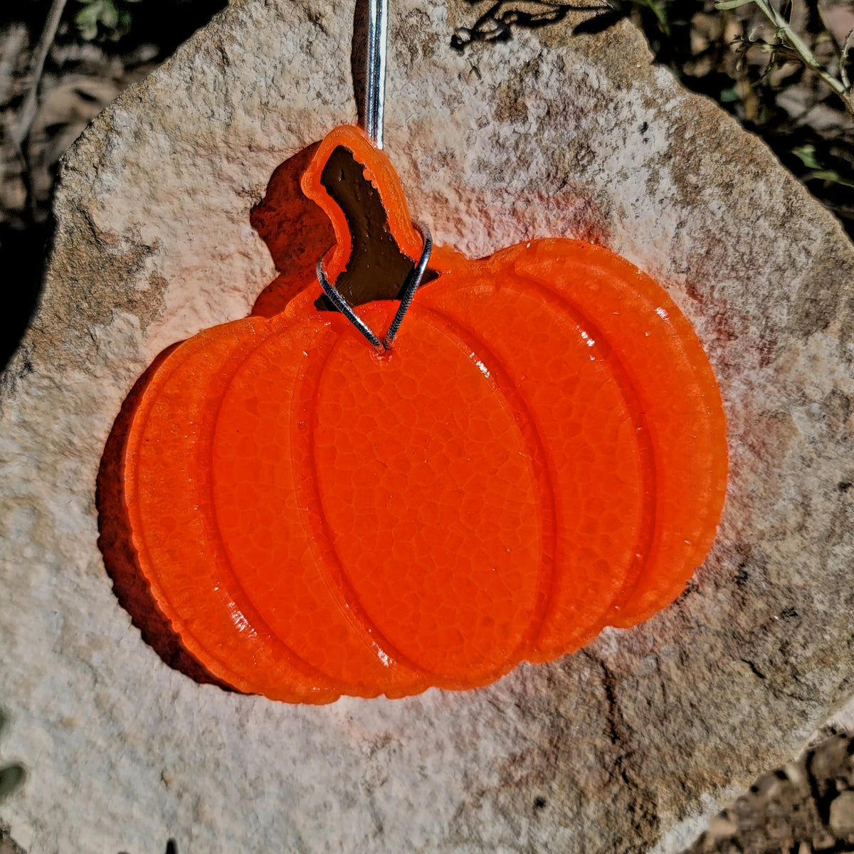 Orange pumpkin freshie hanging outdoors