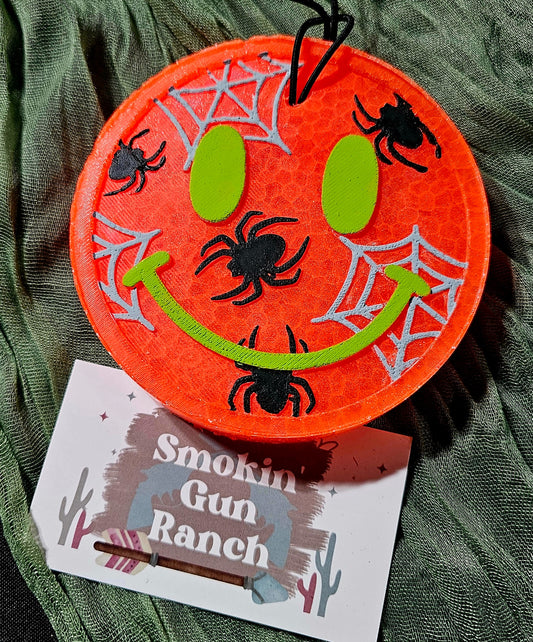 Orange spider smiley Halloween car freshie with lime green face and silver webs