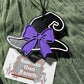 Black witch hat car freshie with a purple bow and white trim