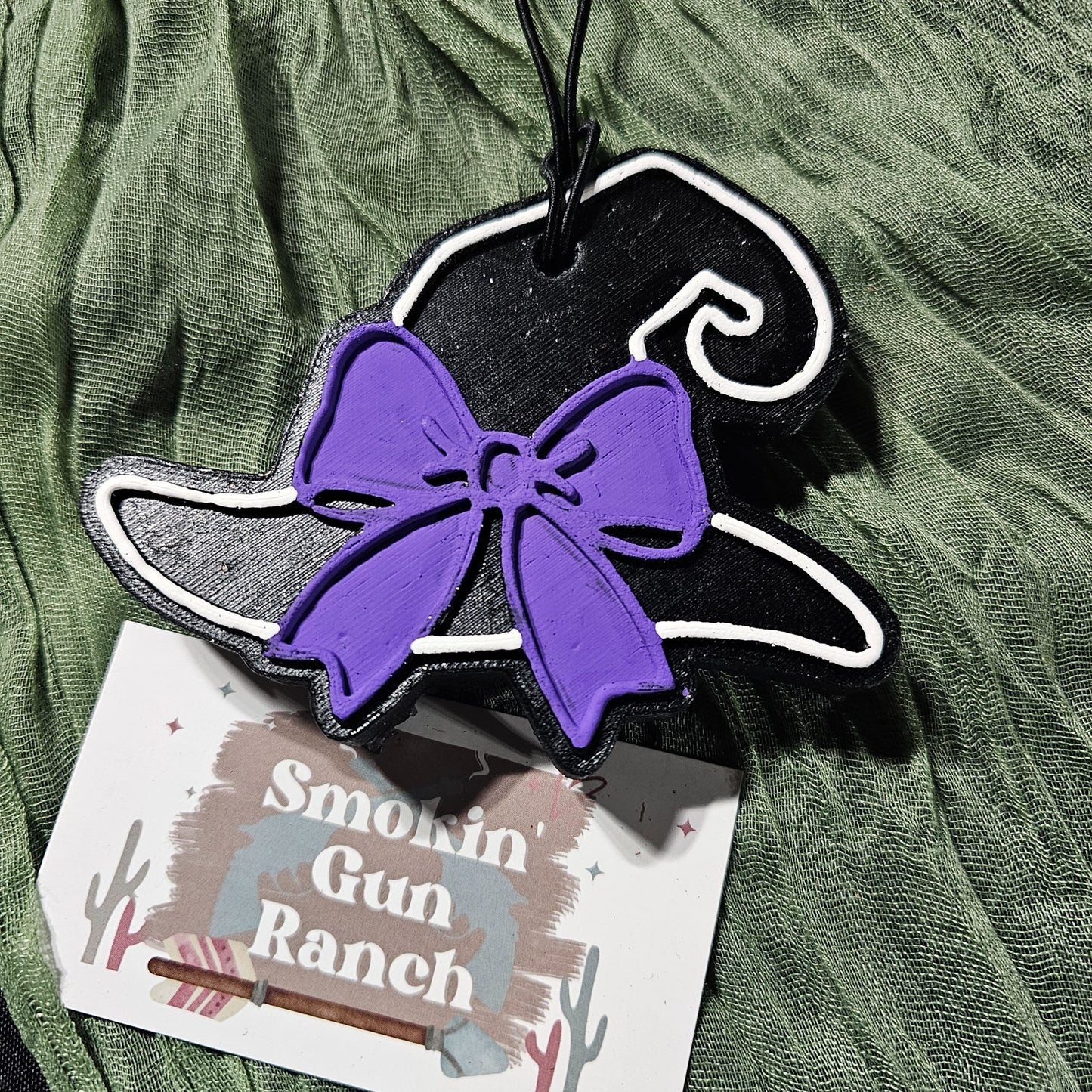 Black witch hat car freshie with a purple bow and white trim